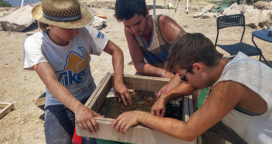 Students performing an archaeological dig abroad 