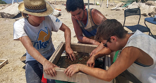 Students performing an archaeological dig abroad