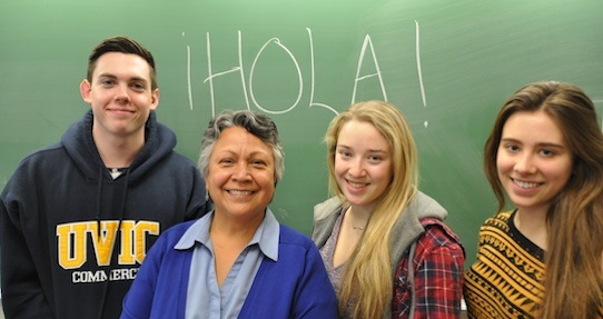 Three students standing in front a chalkboard with Rosa Stewart