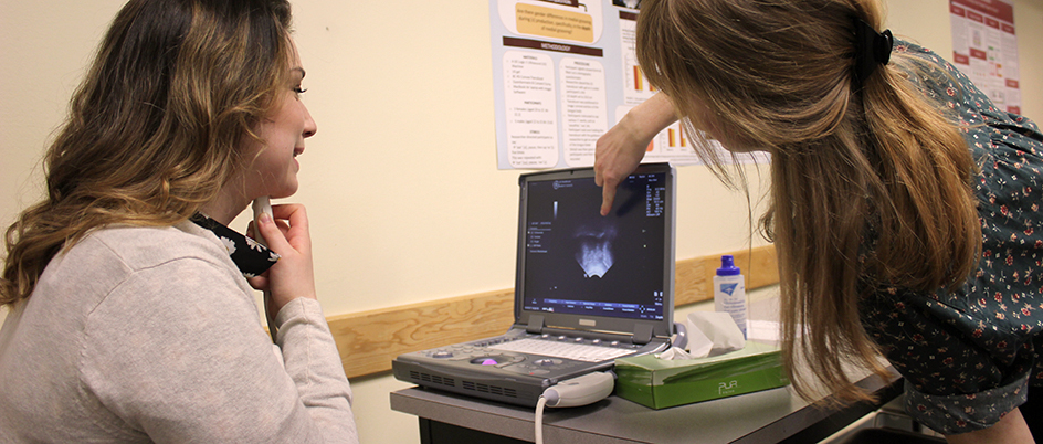 Two undergraduate students use an ultrasound to look at tongue movement