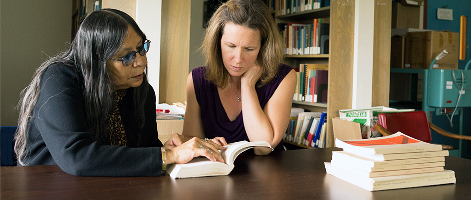 Dr. Heather Bliss reading a book with a member of the Blackfoot Indigenous community