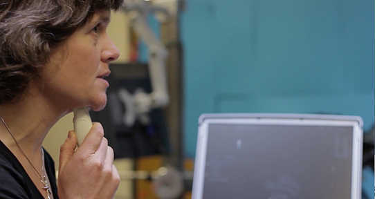 Dr. Sonya Bird holding ultrasound probe under her chin