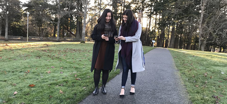 UVic graduates, Kailey Fukushima and Kaitlyn Fralick, test a location-based game they made for mobile phones in a course about play and independent media.
