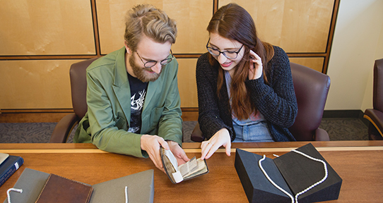 Dylan Kerfoot and Drew Beard work together in the Special Collections room of the library.
