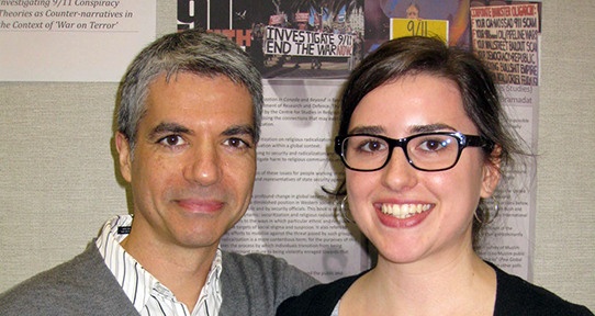 Sarah Mozelle and Paul Bramadat stand in front of Sarah's poster, created as part of the JCURA program.