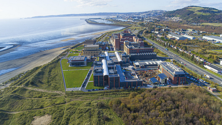 Swansea Bay Campus viewed from above and next to the beach