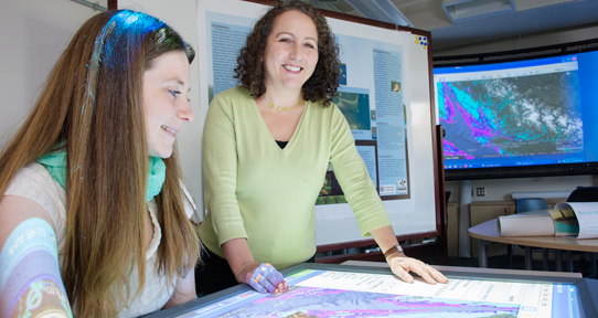 Canessa, standing, and graduate student Cathryn Brandon looking at a map.