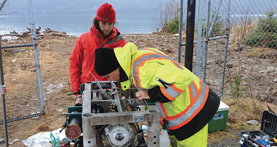 Two members of ONC working on the observatory platform equipment on land