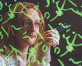Cameron, reflected in a computer screen showing detail of the syphilis bacterium.