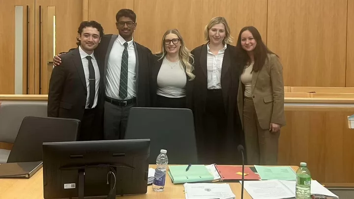 Five Law students pose at a moot competition.