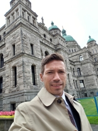 Photo of Stephen Wallington in front of the BC legislative buildings