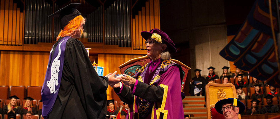 A law student receives their degree on stage at the UVic auditorium