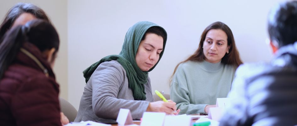 a group of people sitting at a table with papers
