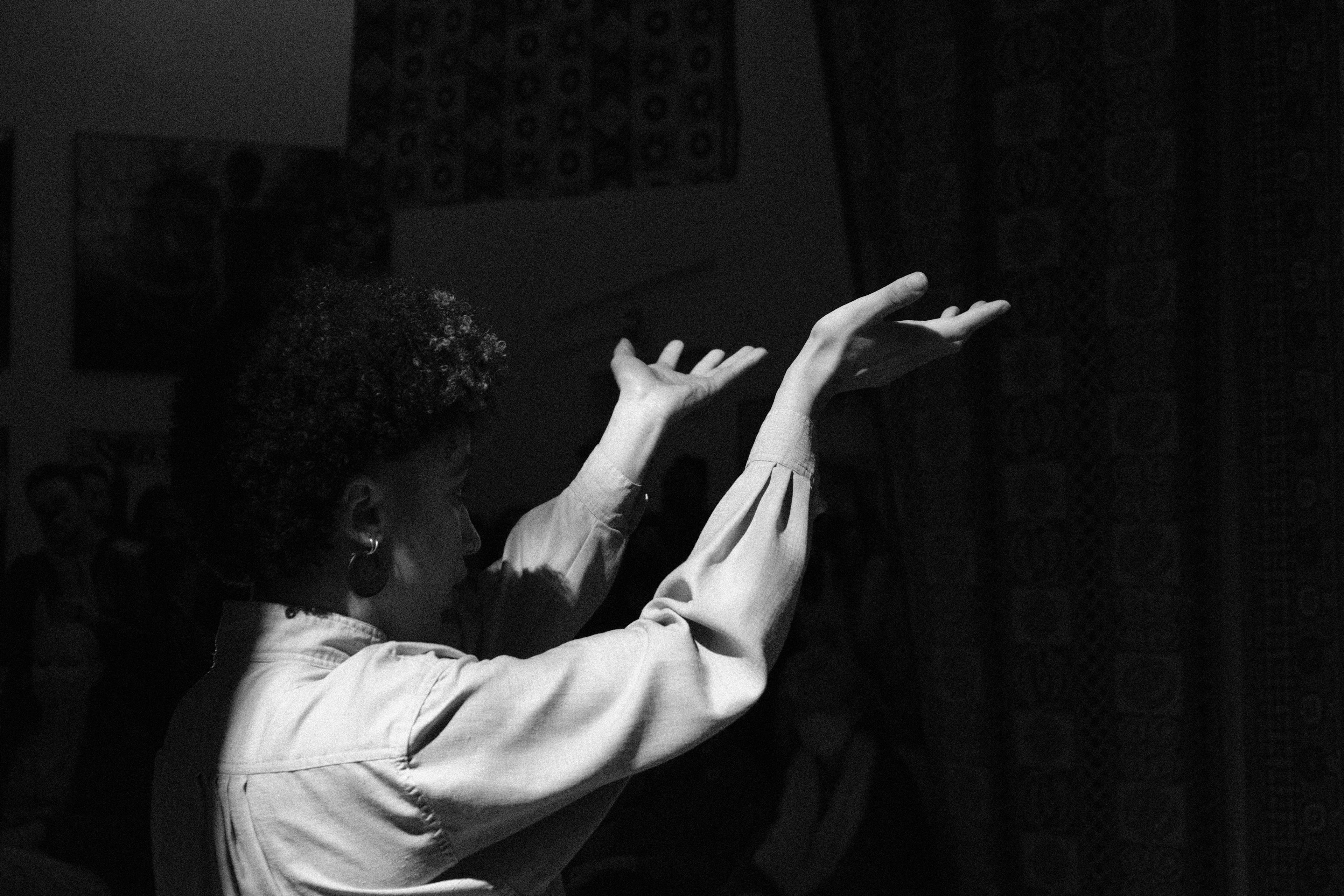 Black and white photo of dancer with hands raised