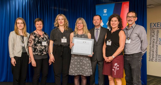 Legacy staff pose with their award