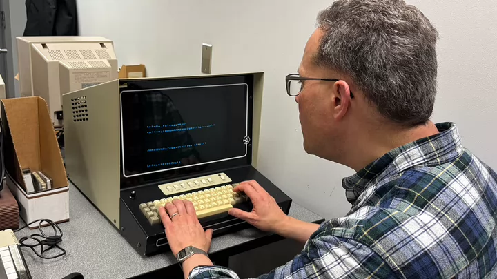 A man sitting at an old style computer