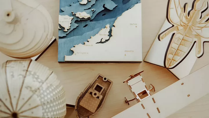A collection of engraved wooden objects, including a map, model plane, and globe.
