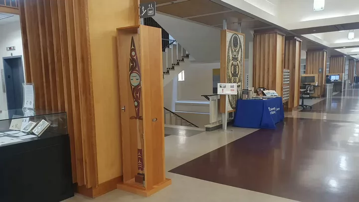 Carved wooden paddle in its case on display in the library lobby