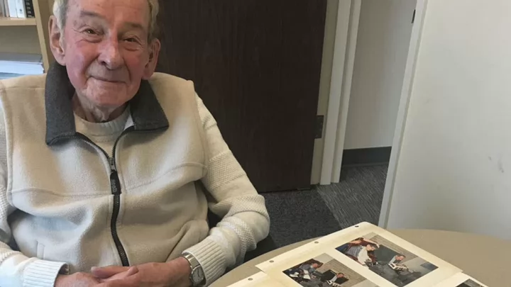 Werner is sitting in an office with an open photo album.