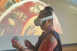 A person wearing a Virtual Reality headset experiences the VR Witness Blanket.