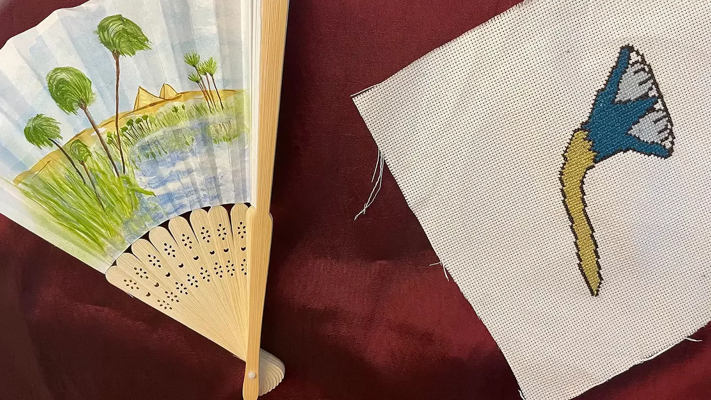 A painted fan and an embroidered flower from Kaela's exhibit.