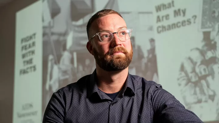 Nathan sitting with a projected image in the background.