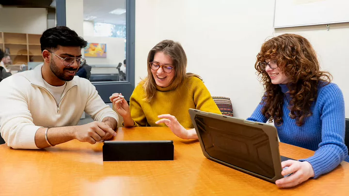 Librarian helping students in a study room.
