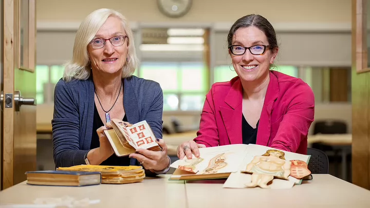 Lisa and Mary Elizabeth holding Victorian publications from Special Collections.