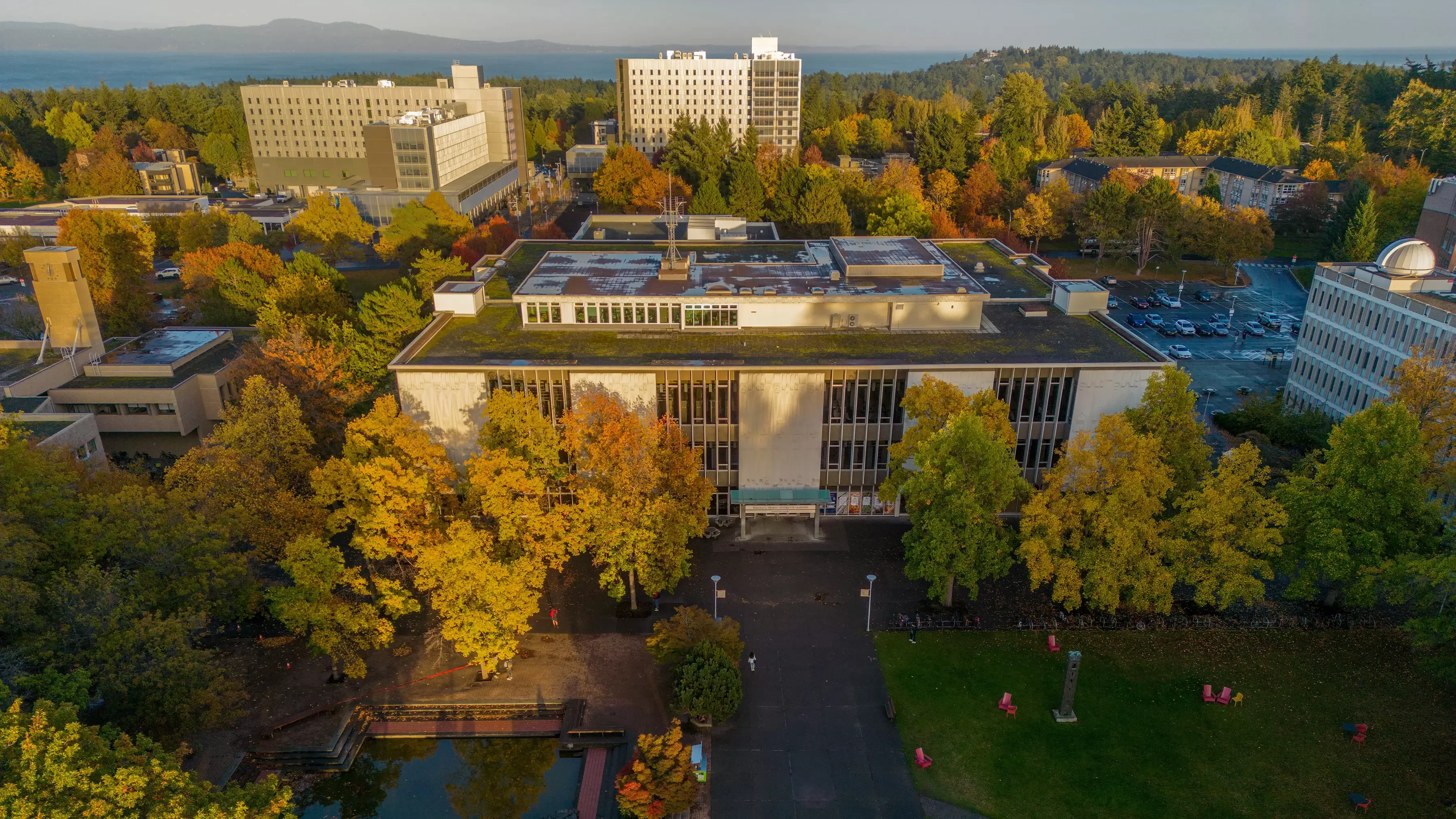 Aerial photo of the McPherson Library building with the UVic campus and distant ocean in the background