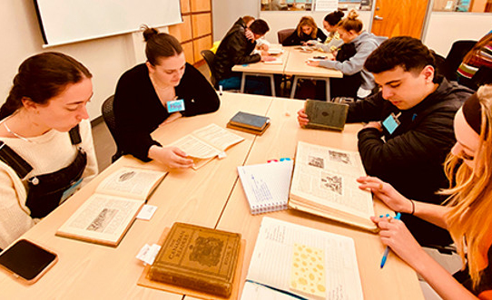 Students at a table looking at textbooks and making notes