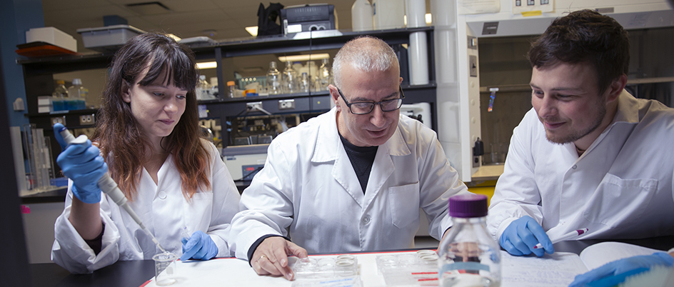 Two UVic students with Dr. Hector Cauncho in the lab.