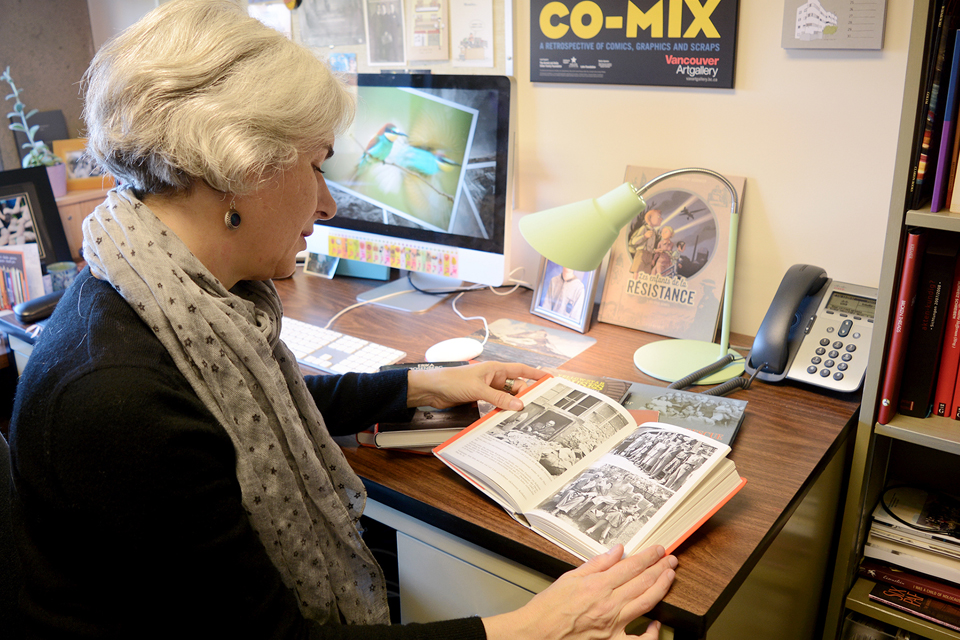 Schallie in her office looking at archival materials