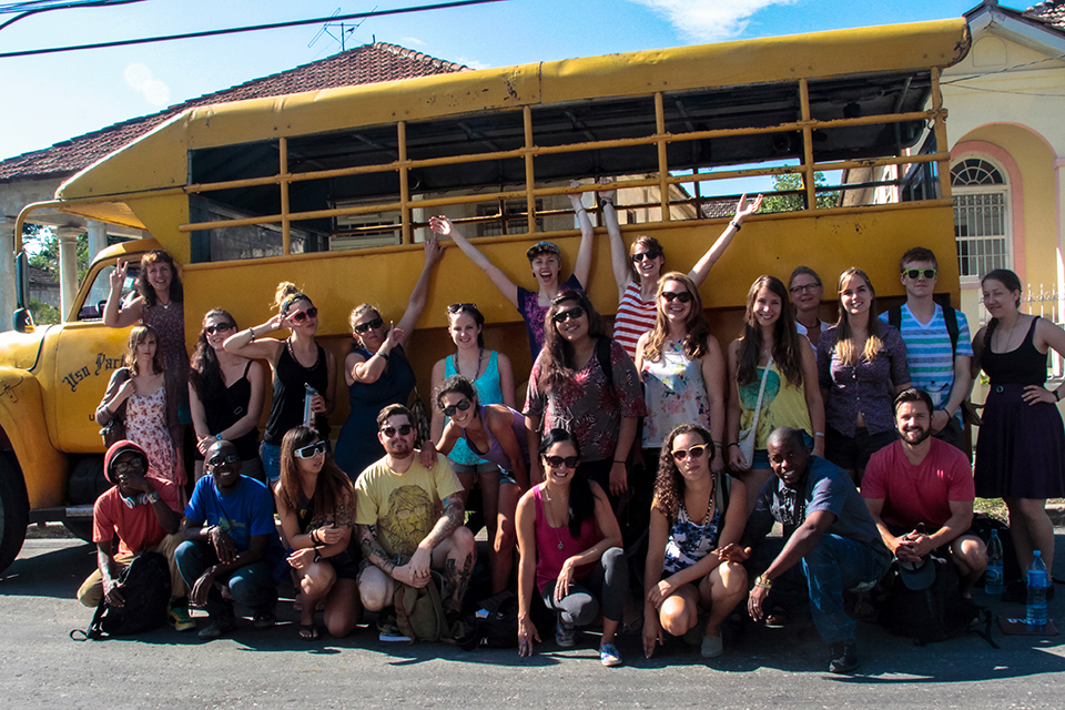 Students in front of a yellow school bus in Cuba