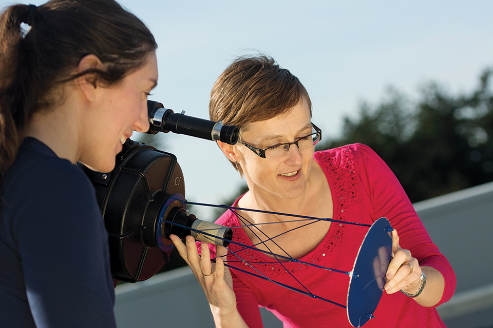 UVic astronomy Sara Ellison looking at a telescope with a student