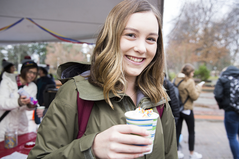 Student drinking hot chocolate at Giving Tuesday event
