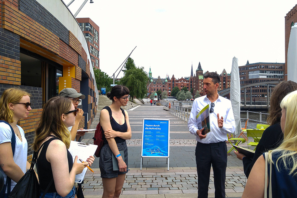 UVic students on a street in European listening to their instructor speak