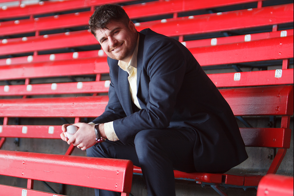 JC Fraser sitting on benches at a baseball park