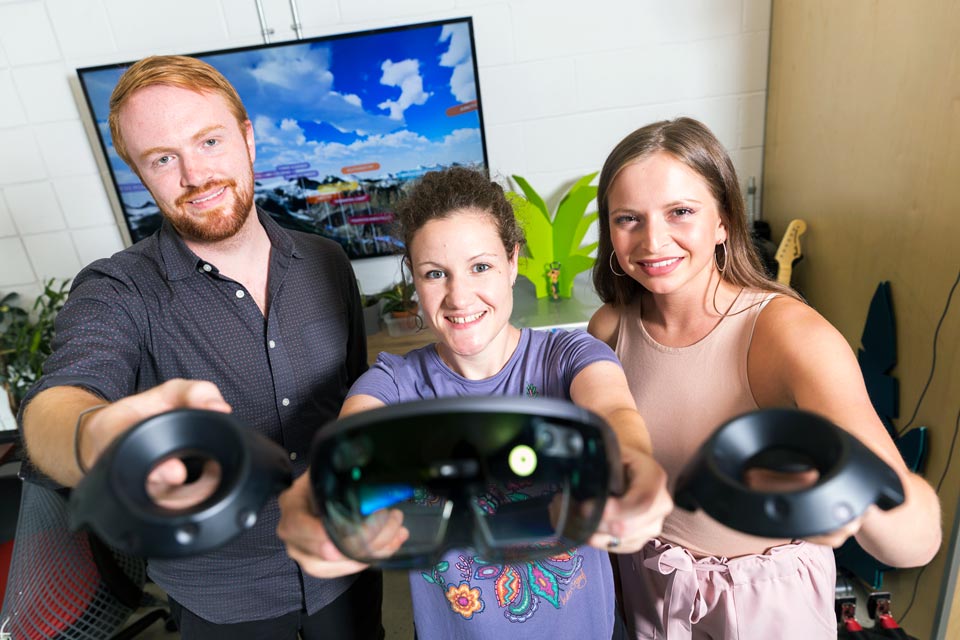 Three people holding virtual reality sets