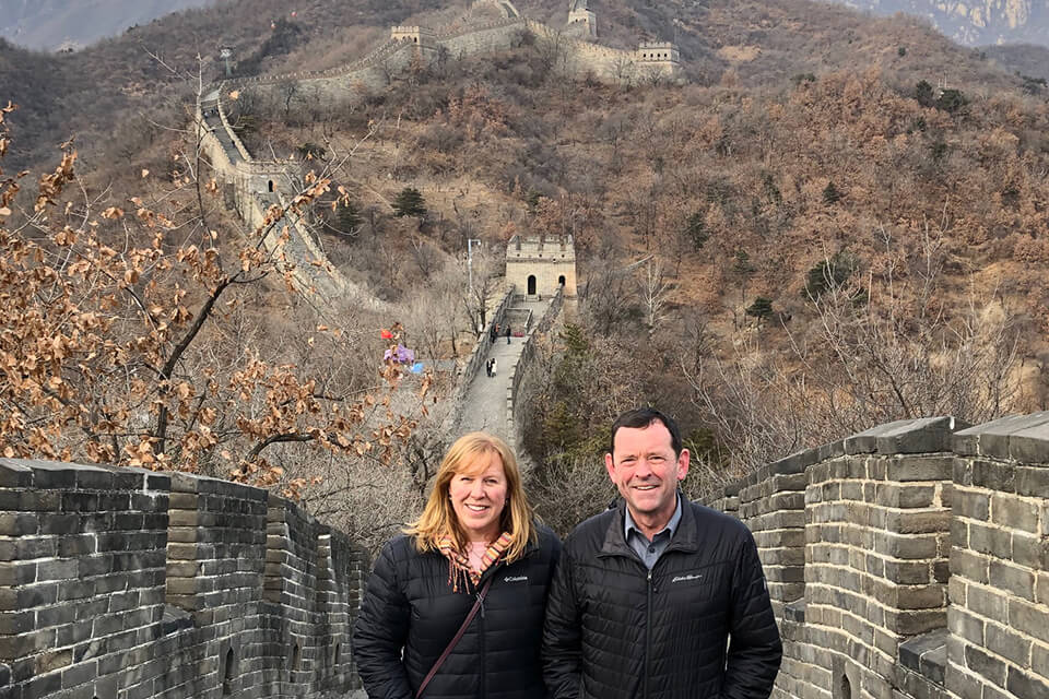 Carolyn Russell and Jamie Cassels standing on the Great Wall of China