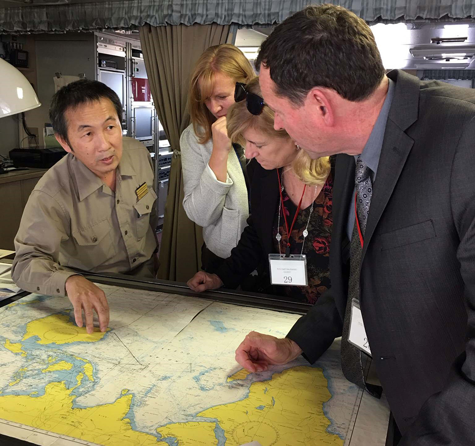 Cassels, Krull and Russell speaking with Capt. Noda on a ship