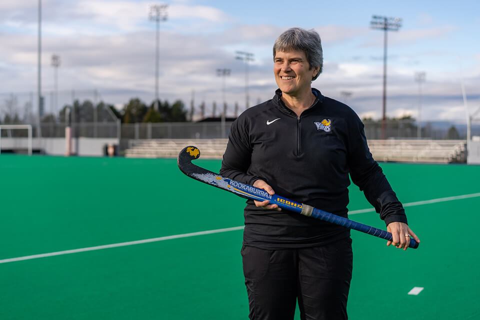 UVic Vike Sara Brant (Ballantyne) holding a field hockey stick