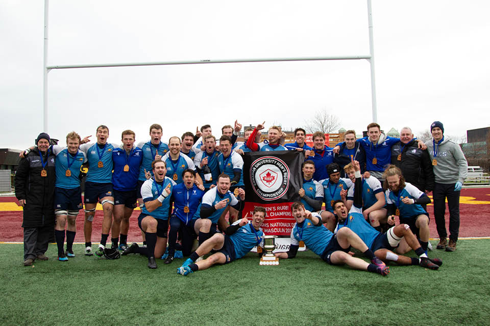 Vikes men's rugby team photo with winning trophy.