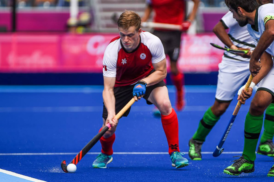 Brenden Bissett dribbles a field hockey ball for team Canada