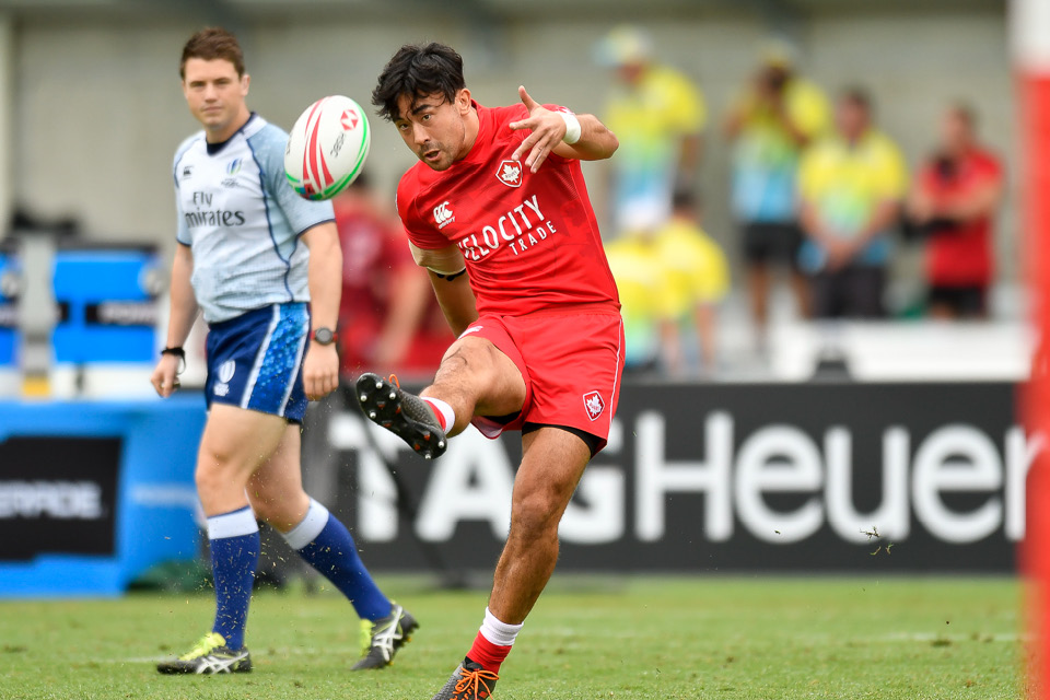 Nathan Hirayama kicks a rugby ball in an international tournament for Canada.