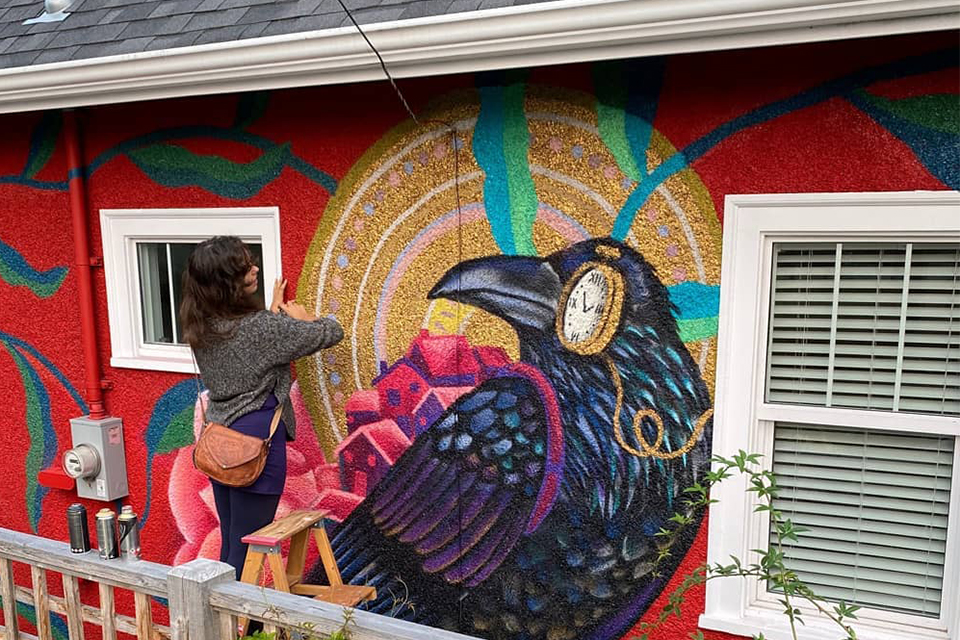 Gallivan painting a mural outside