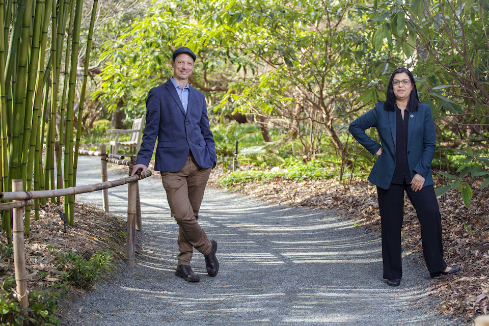 Photo of two Gustavson researchers stand in Finnerty Gardens. 