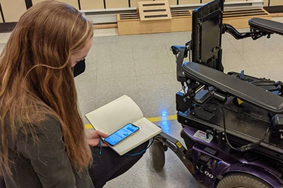BMED team member assessing MobilArm prototype