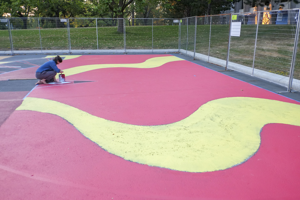 Emily Thiessen works on her mural