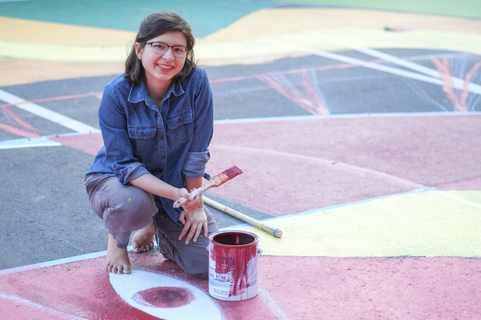 Emily Thiessen works on her mural