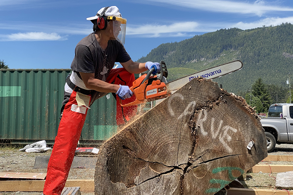 Master carver carving the canoe from the log of wood